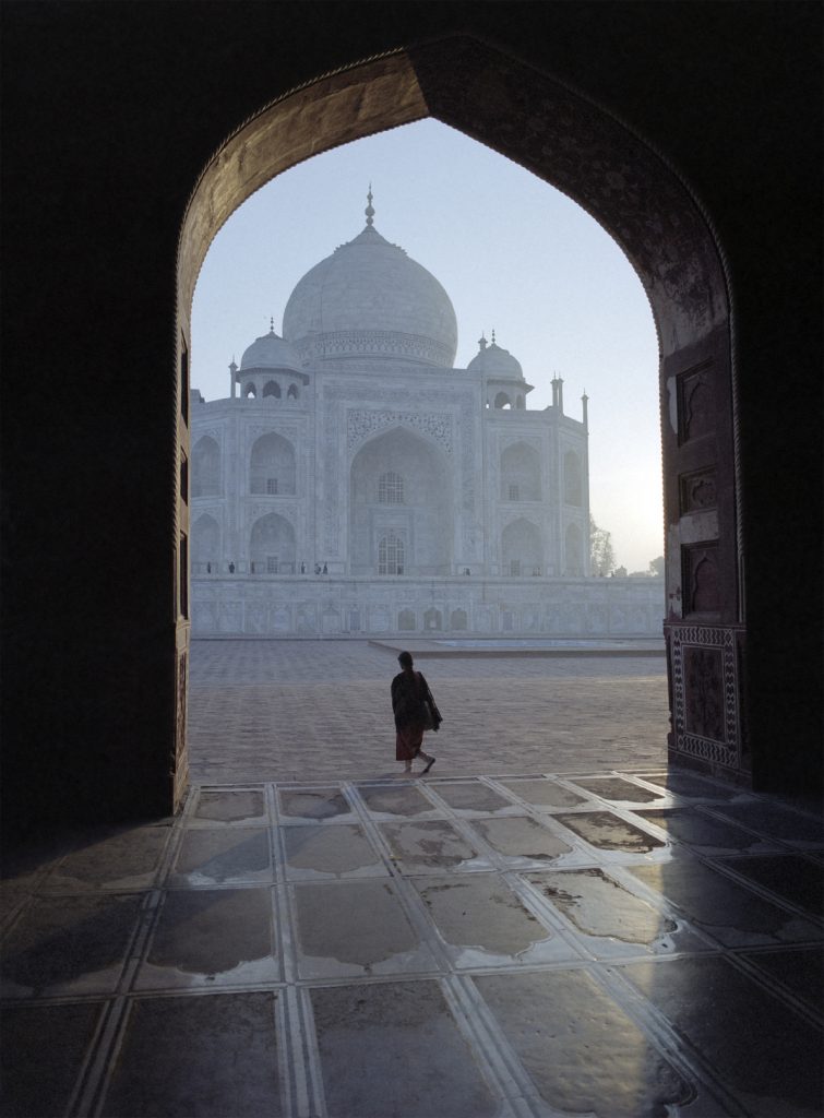 Silhouette of a woman in a sari in the early morning at the Taj Mahal