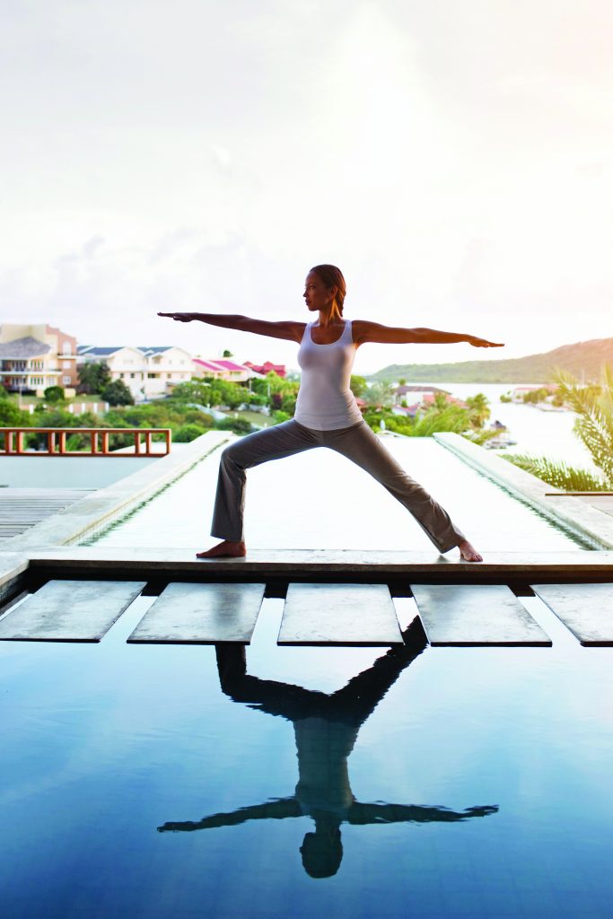 Young woman doing yoga on patio --- Image by © Felix Wirth/Corbis